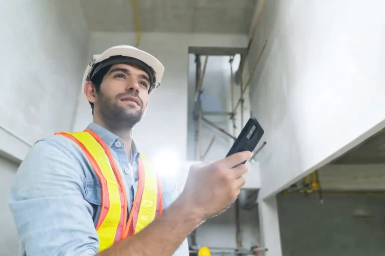 portrait young caucasian male engineer wearing uniform hard hat hand use smartphont communication site construction background (2)